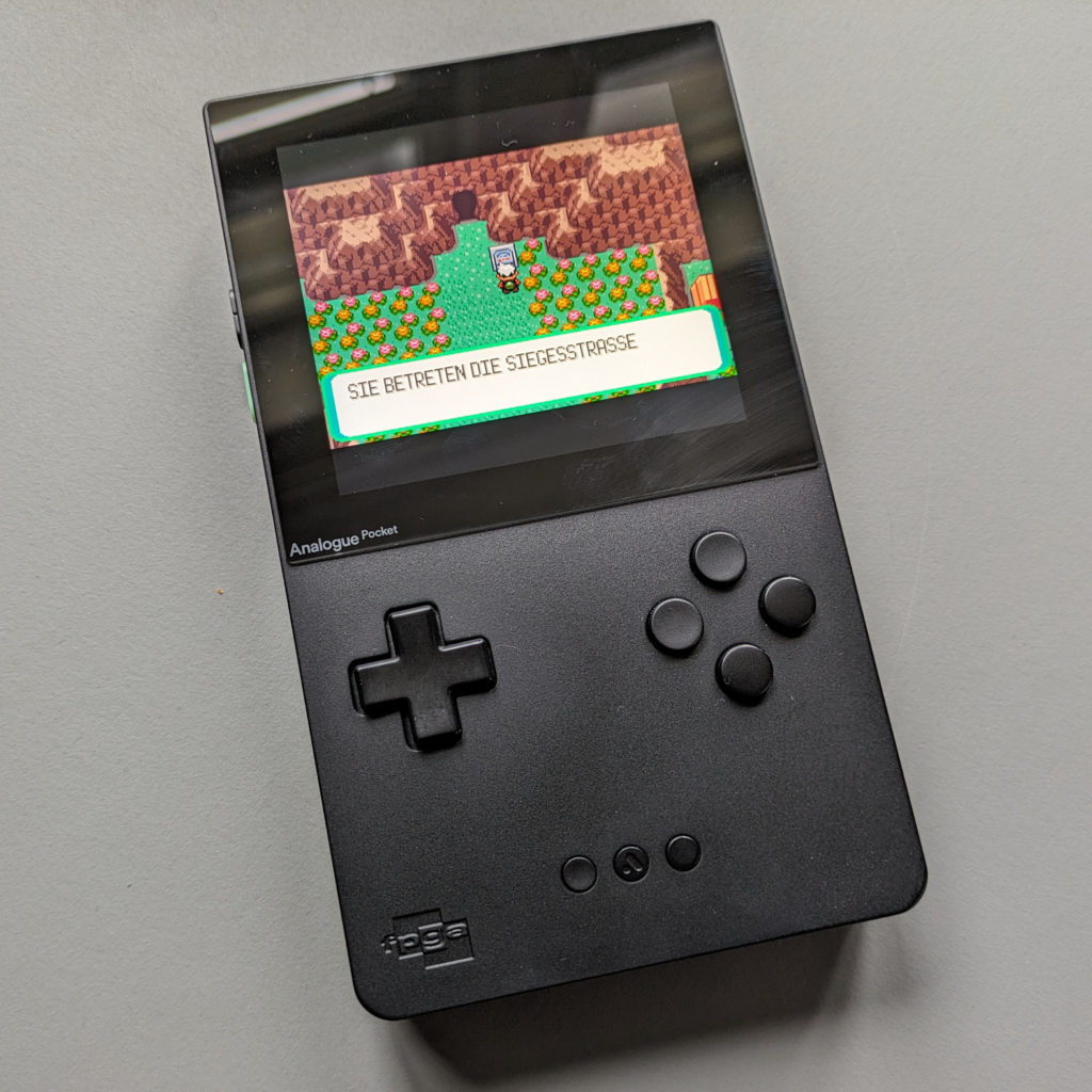 Das Game Boy Advance Spiel Pokémon Smaragd auf dem Analogue Pocket Handheld. Der Protogonist steht vor dem eingang zur Siegerstraße